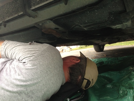 Here is Corey ensuring I got the bolt properly tightened so I wouldn't leak oil when we poured the new oil in. He also helped me get the old oil filter off - it was screwed on preeeeety tightly!